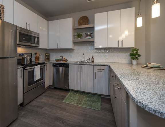 A modern kitchen with stainless steel appliances and white cabinets.