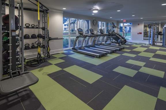 A gym with treadmills, weights, and exercise equipment.