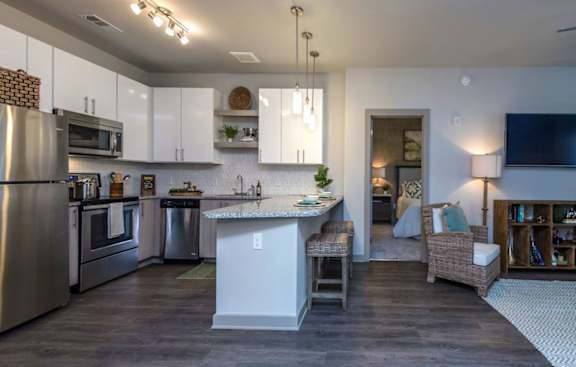A modern kitchen with a large island and stainless steel appliances.
