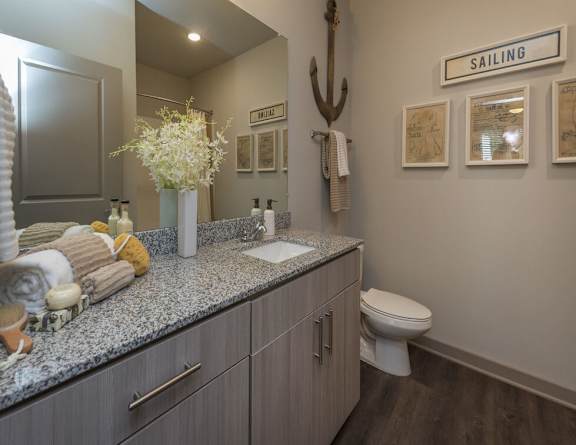 A bathroom with a toilet, sink, and a sign that says "SAILING" on the wall.