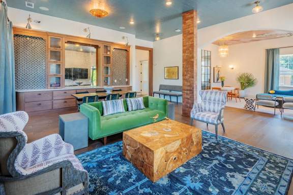 A living room with a green couch and a wooden coffee table.