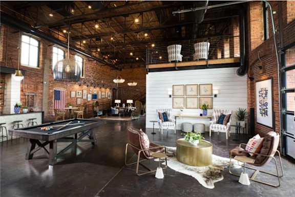 A room with a pool table and a bar area.