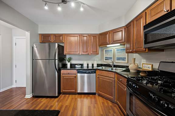 A kitchen with wooden cabinets and a black stove top oven.