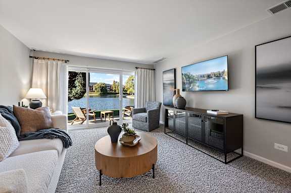 A living room with a large window overlooking a body of water.
