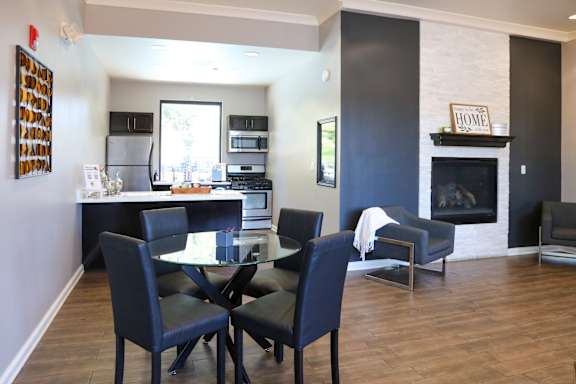 a kitchen and living room with a table and chairs and a fireplace