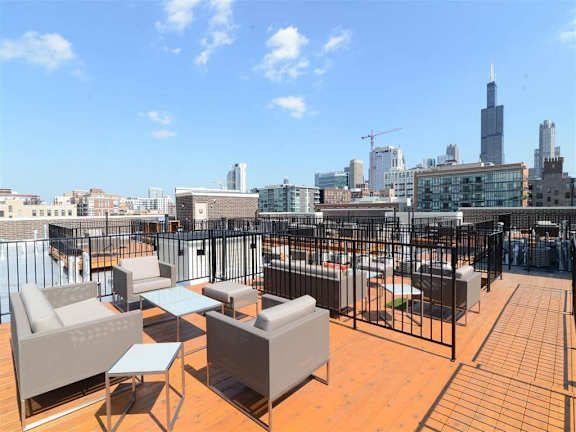 A rooftop patio with a view of the city skyline.