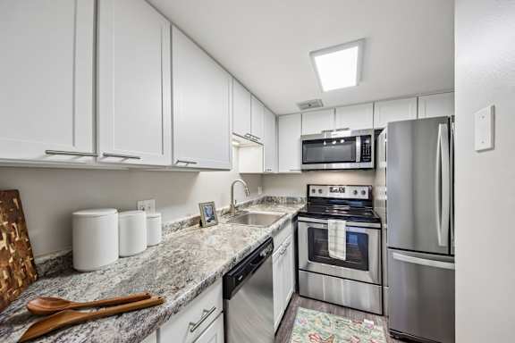 A kitchen with a refrigerator, oven, and microwave.