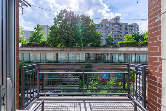 A balcony with a metal railing and a brick wall.