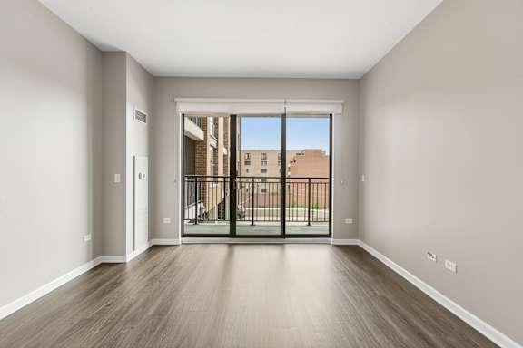 A room with a sliding glass door leading to a balcony.