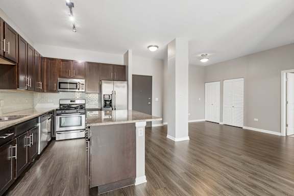 A kitchen with dark wood cabinets and stainless steel appliances.