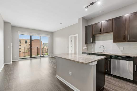 A kitchen with a large island and stainless steel appliances.