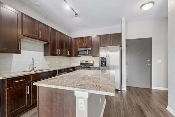 A kitchen with brown cabinets and a granite countertop.
