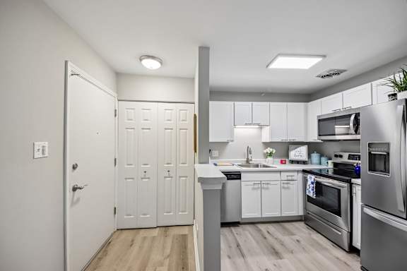 A modern kitchen with stainless steel appliances and white cabinets.