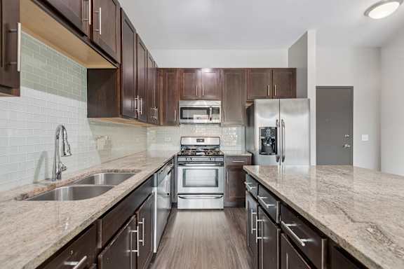 A kitchen with brown cabinets and a stainless steel refrigerator.