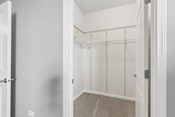 A white door is open to a room with a carpeted floor.