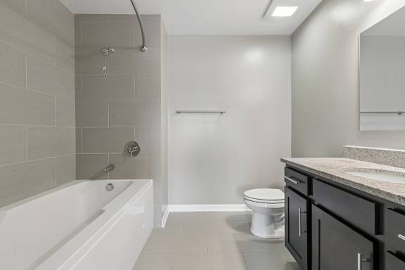 A white bathroom with a white tub, toilet, and sink.