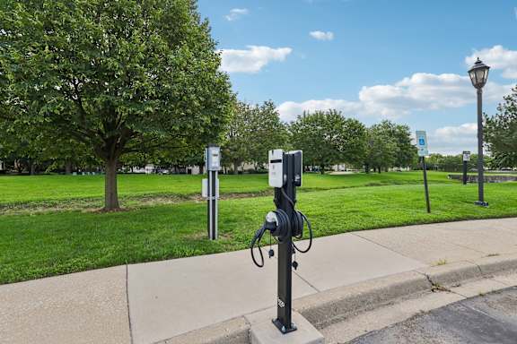 A black and white electric car charging station on a sidewalk.
