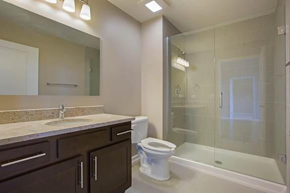 A bathroom with a toilet, sink, and shower.