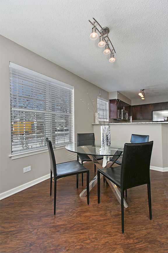 A dining room with a table and chairs.