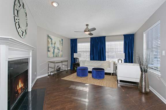A living room with a fireplace and a blue rug.