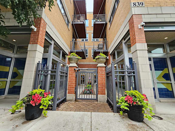 The entrance to a building with a gate and flower pots on either side.