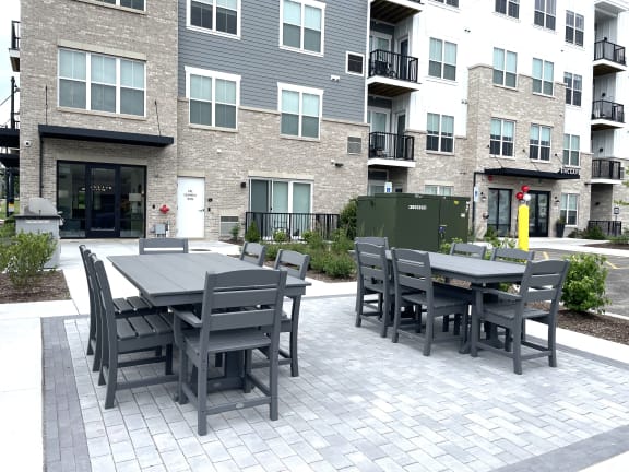 a patio with a table and chairs in front of an apartment building at Enclave Crystal Lake Townhomes and Apartments, Illinois, 60014