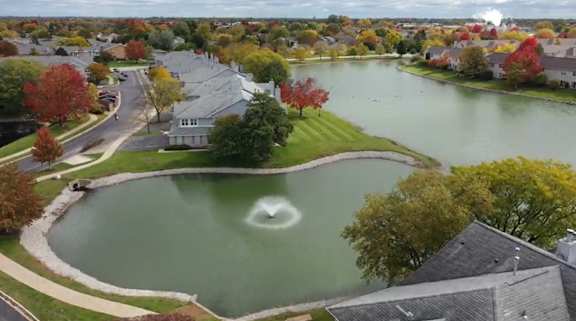 A heart-shaped island in the middle of a lake surrounded by houses.