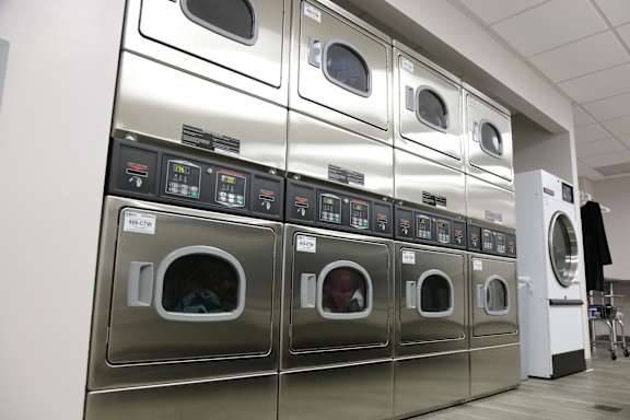 A row of industrial washing machines are lined up in a row.