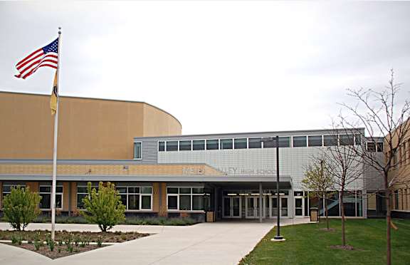 Metea Valley High School building with American flag on pole.