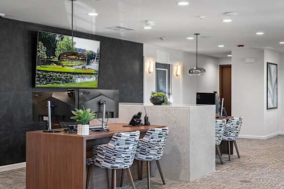 A modern office space with a large screen TV mounted on the wall.