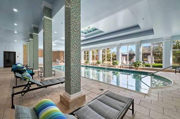 A large indoor swimming pool with a sunken seating area.