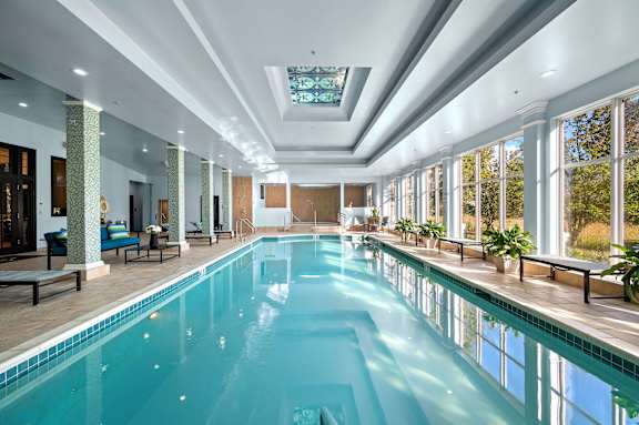 A large indoor swimming pool with a skylight above it.