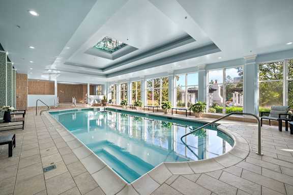 A large indoor swimming pool with a skylight above it.