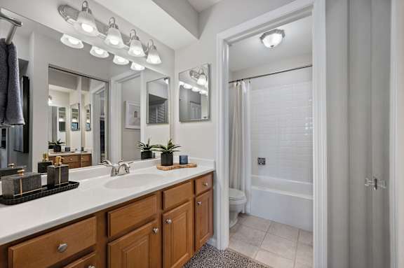 A bathroom with a white sink and brown drawers.