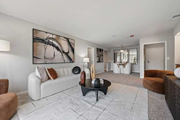 A modern living room with a large abstract painting on the wall.