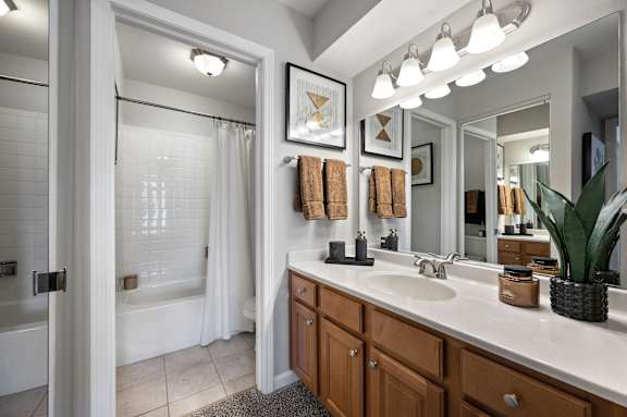 A bathroom with a white tub and sink.
