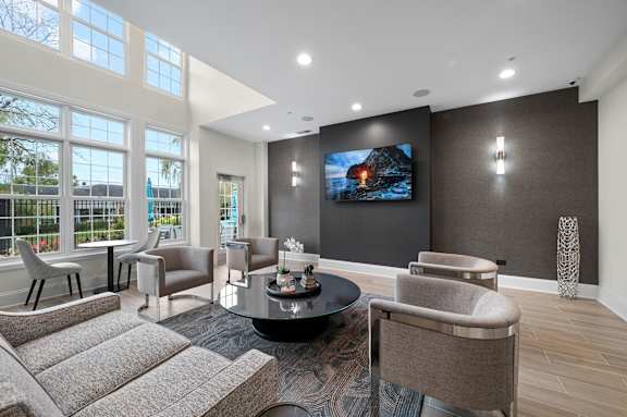 A modern living room with a large screen TV and comfortable seating.