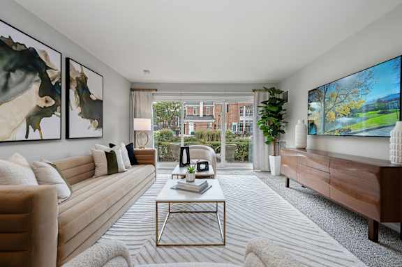 A living room with a large painting on the wall and a flat screen TV mounted on the wall.
