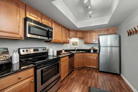 A kitchen with wooden cabinets and black appliances.