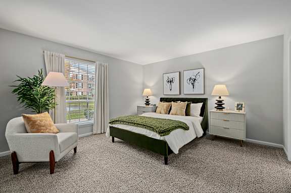 A bedroom with a bed, nightstand, chair, and lamp.