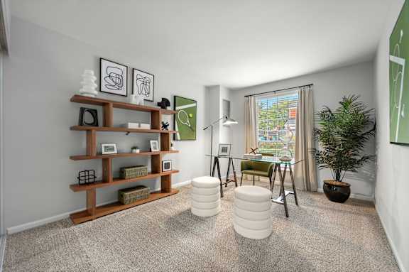 A room with a carpeted floor, a wooden shelf, a green chair, a white ottoman, and a potted plant.