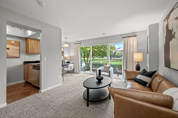 A living room with a brown leather couch and a grey coffee table.