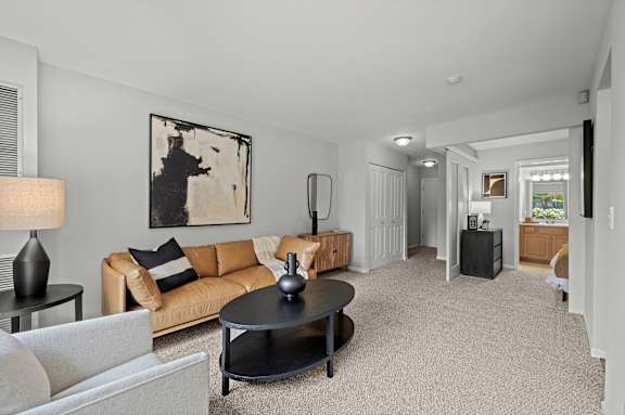 A living room with a couch, coffee table, and lamp.