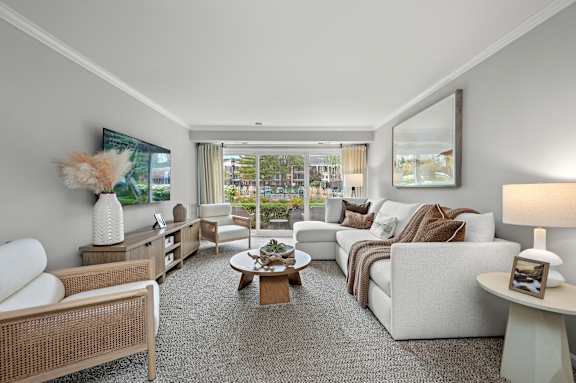 A well-lit, spacious living room with a variety of seating options and a coffee table.