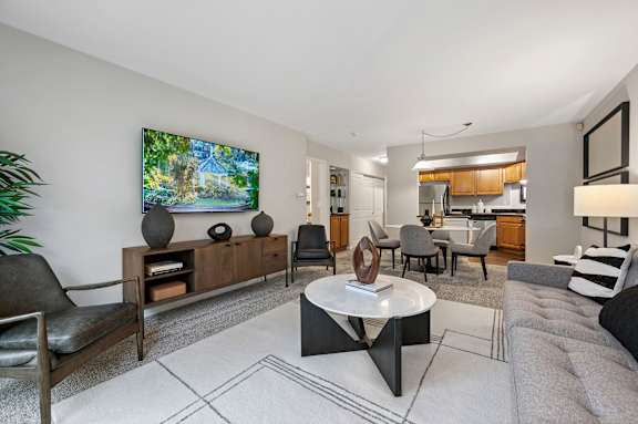 A modern living room with a flat screen TV mounted on the wall.