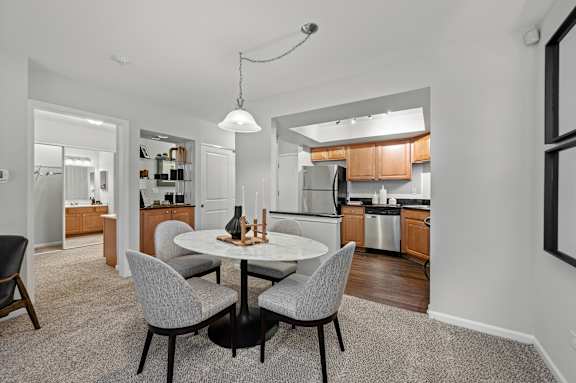 A modern kitchen with a dining table and chairs.