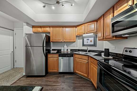 A modern kitchen with wooden cabinets and stainless steel appliances.