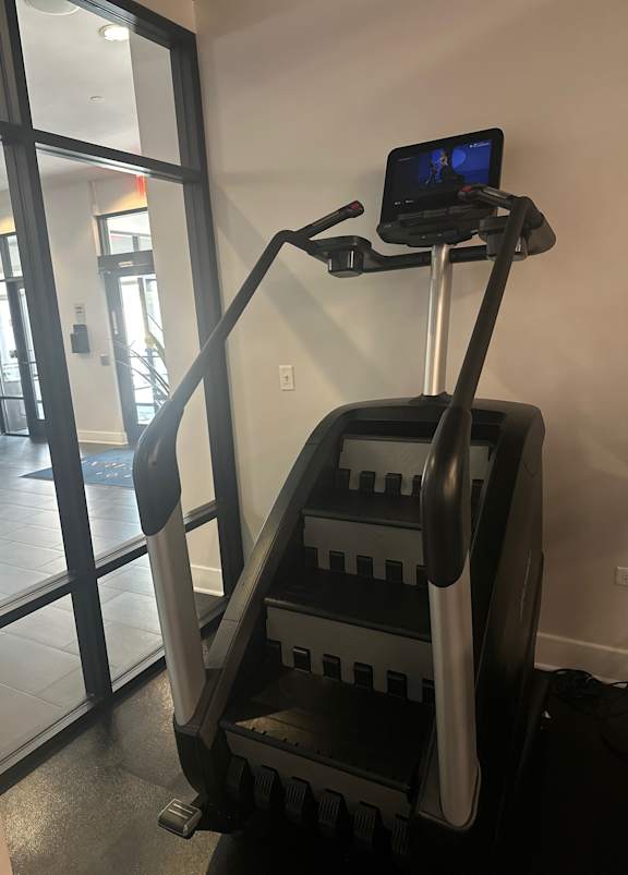 A treadmill with a screen on top is in a room.