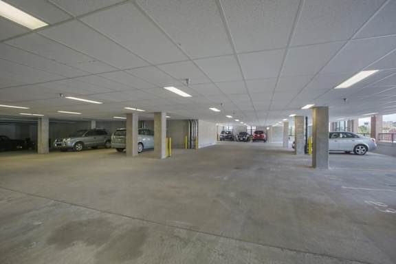 A parking garage with several cars parked in it.
