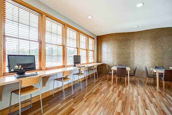 A room with wooden floors and a long table with chairs.